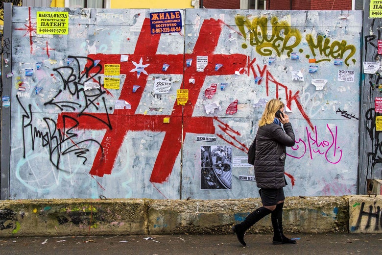 A woman speaks on a mobile phone as she walks past a graffiti covered wall with a giant hashtag sign near Moscow's Kursky railway station on November 17, 2017. / AFP PHOTO / Mladen ANTONOV (Photo credit should read MLADEN ANTONOV/AFP/Getty Images)